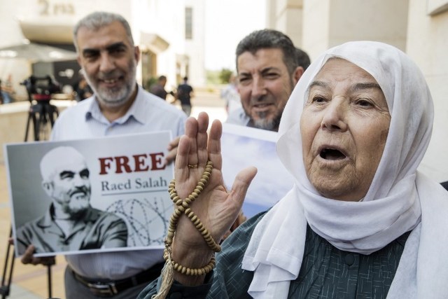 arab israeli supporters of sheikh raed salah portrait leader of the radical northern branch of the islamic movement in israel gather in protest against the arrest and detention of the sheikh outside the israeli rishon lezion justice court near tel aviv on august 17 2017 photo afp