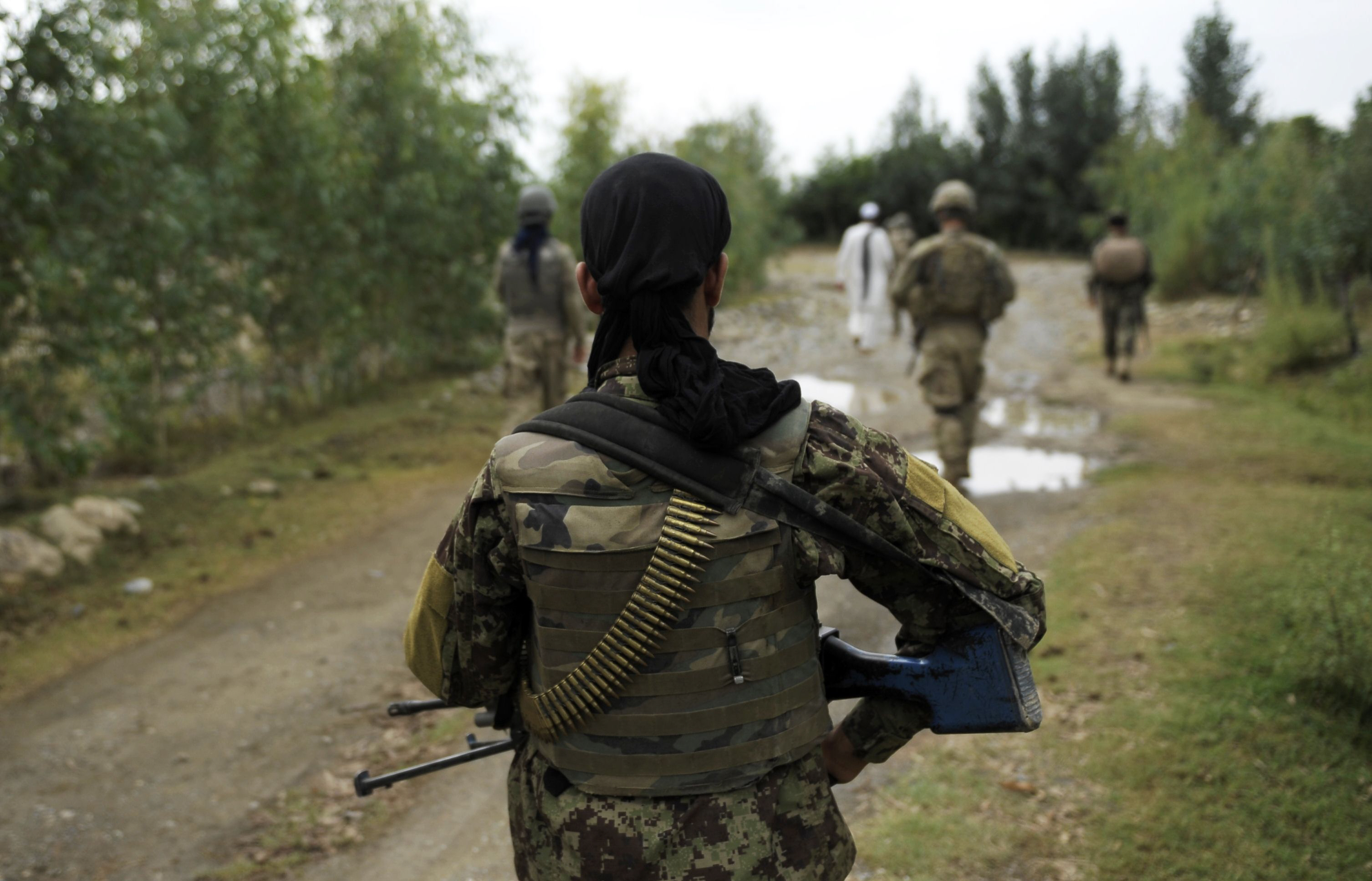 in this photograph taken on august 5 2012 an afghan national army soldier walks during a patrol with us soldiers from apache team task force geronimo in the village of karizona sabari district in khost province photo afp