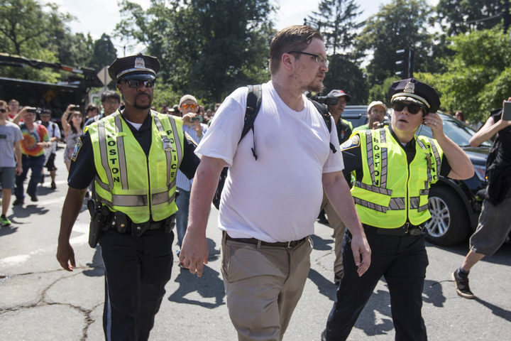 a participant of the quot free speech rally quot center is escorted to a waiting police cruiser after the rally was ended on boston common on august 19 2017 in boston massachusetts thousands of demonstrators and counter protestors are expected at boston common where the boston free speech rally is being held photo afp