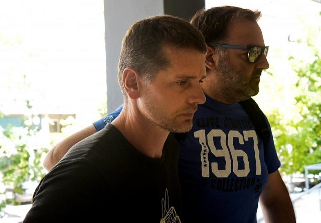 alexander vinnik a 38 year old russian man l suspected of running a money laundering operation is escorted by a plain clothes police officer to a court in thessaloniki greece july 26 2017 photo reuters