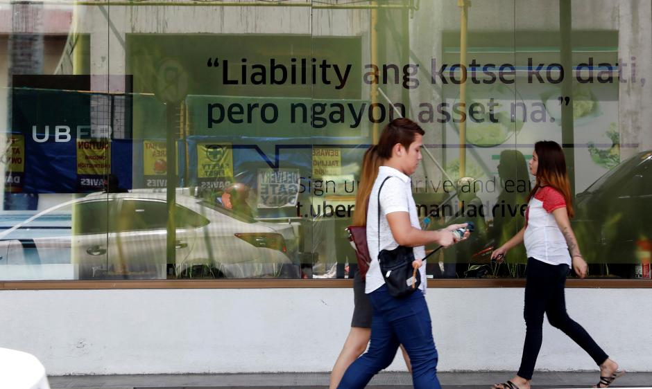 people walk past an uber advertisement outside the uber main office in mandaluyong city metro manila philippines august 15 2017 photo reuters