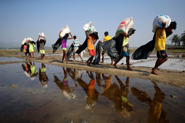 rohingya refugee workers carrying bags of salt in a processing yard in cox 039 s bazar bangladesh photo reuters mohammad ponir hossain