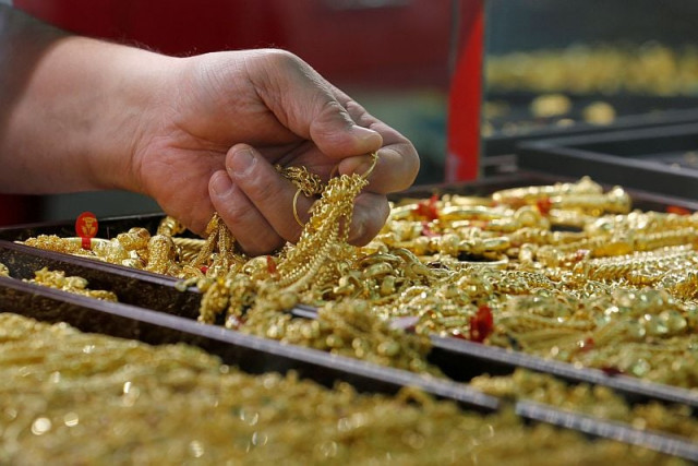 a salesman holds gold to sell to a customer at a gold shop photo reuters a salesman holds gold to sell to a customer at a gold shop photo reuters