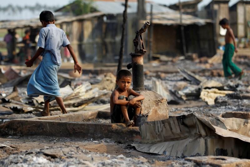 a boy sit in a burnt area after fire destroyed shelters at a camp for internally displaced rohingya muslims in the western rakhine state near sittwe myanmar photo reuters