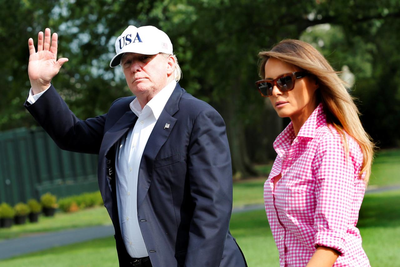u s president donald trump waves as he walks with first lady melania trump on south lawn of the white house upon their return to washington us from camp david photo reuters