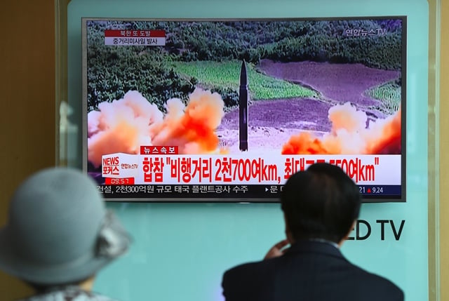 people watch a television news screen showing file footage of a north korean missile launch at a railway station in seoul on august 29 2017 photo afp