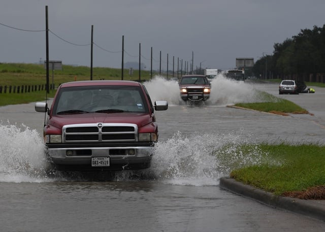 vehicles drive along a flooded road beside the barker reservoir after the army corp of engineers started to release water into the clodine district as hurricane harvey caused heavy flooding in houston texas on august 29 2017 photo afp vehicles drive along a flooded road beside the barker reservoir after the army corp of engineers started to release water into the clodine district as hurricane harvey caused heavy flooding in houston texas on august 29 2017 photo afp