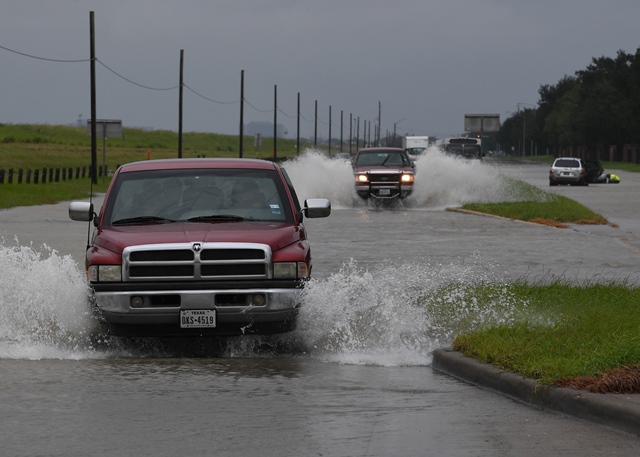 vehicles drive along a flooded road beside the barker reservoir after the army corp of engineers started to release water into the clodine district as hurricane harvey caused heavy flooding in houston texas on august 29 2017 photo afp