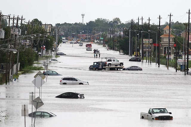 a car gets towed while men walk in the flooded waters of telephone rd in houston texas photo afp a car gets towed while men walk in the flooded waters of telephone rd in houston texas photo afp