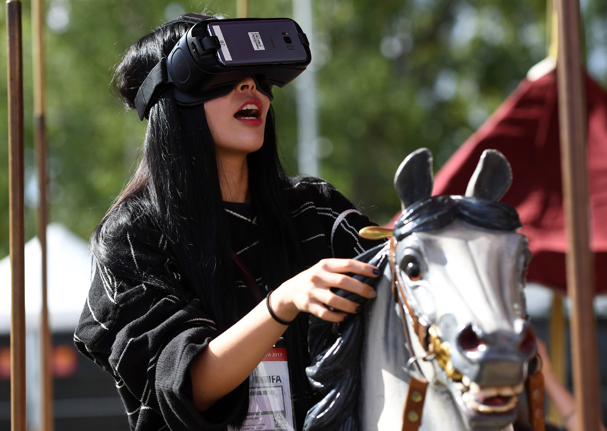 a visitor sitting on a carousel tries out virtual glasses at the booth of deutsche telekom at the ifa consumer electronics fair in berlin on september 2 2017 photo afp