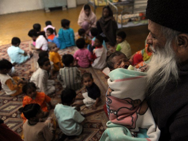 in this photograph taken on december 6 2010 abdul sattar edhi head of pakistani 039 s edhi foundation holds a disabled orphan at the orphanage of the charity in karachi photo afp