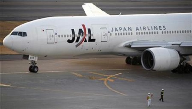 airport ground staff work while a boeing 772 aircraft of japan 039 s largest airline japan airlines corp jal taxis at haneda airport in tokyo january 17 2009 photo reuters stringer