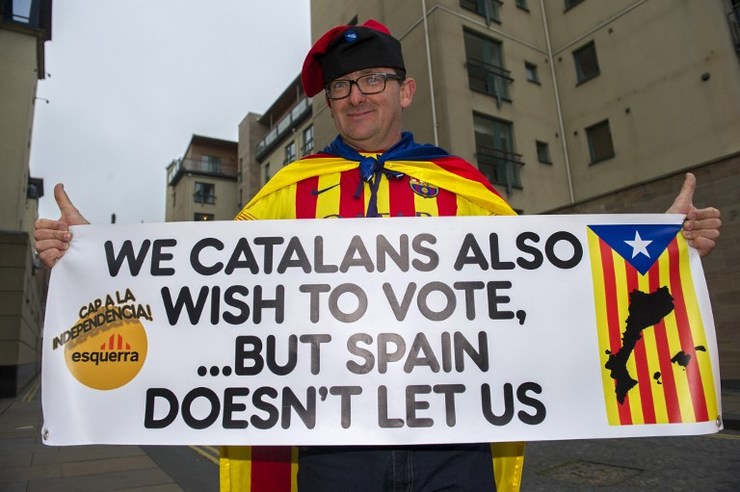 a catalan supporter of the 039 yes 039 campaign holds up a banner outside the scottish parliament in edinburgh on september 18 2014 photo afp