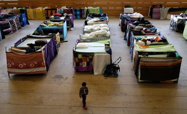 a migrant child walks at the sports hall of the jane addams high school which has been transformed into a refugee shelter in berlin 039 s hohenschoenhausen district germany february 2 2016 photo reuters fabrizio bensch