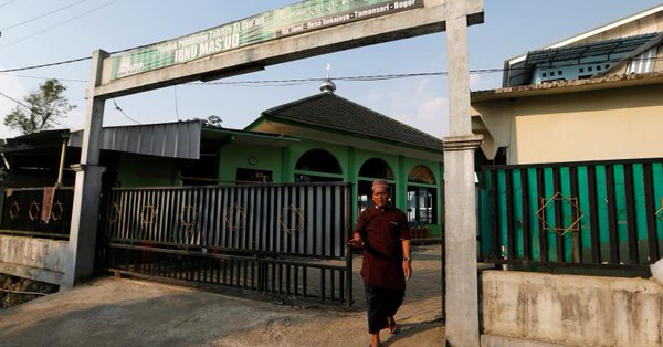 a security guard for the ibnu mas 039 ud islamic boarding school blocks the gate of the compound in bogor indonesia photo reuters