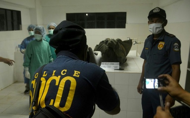 coroners at a funeral parlour look at the remains of german hostage jurgen kantner in jolo the philippines after he was beheaded in february by the abu sayyaf photo afp