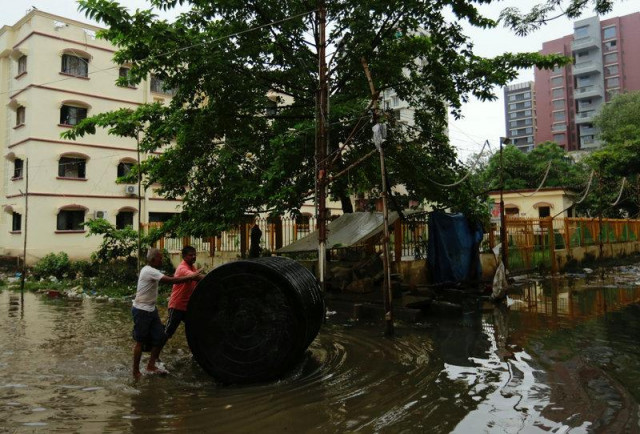 men push a water tank through a partially flooded street at a residential area in mumbai india photo reuters men push a water tank through a partially flooded street at a residential area in mumbai india photo reuters