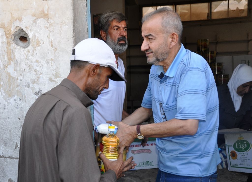 residents of the northeastern syrian city of deir ezzor receive aid parcels on september 8 2017 as the first the supplies since government troops broke a jihadists siege were delivered via a newly opened road photo afp