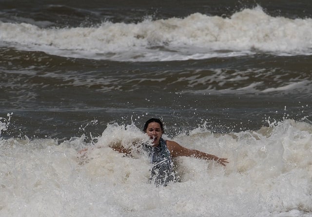 a woman plays in the surf in naples florida on september 11 2017 after hurricane irma hit florida millions of florida residents were without power and extensive damage was reported in the florida keys but most of the sunshine state appeared to have dodged forecasts of catastrophic damage from hurricane irma photo afp