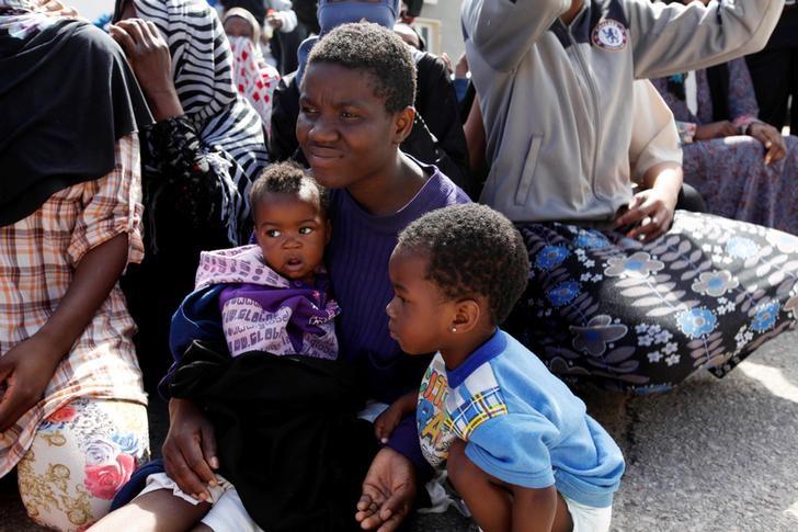 an illegal african migrant sits with his children during a visit by un special representative and head of the united nations support mission in libya martin kobler and international organization for migration director general william lacy swing at a detention camp in tripoli libya march 22 2017 photo reuters