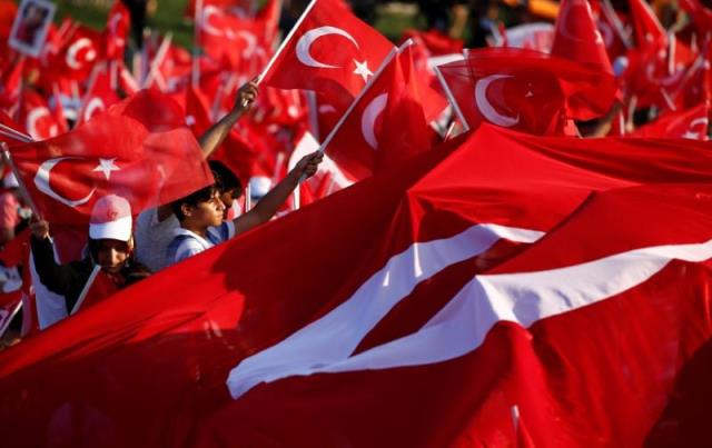 people wave turkey 039 s national flags as they attend a ceremony marking the first anniversary of the attempted coup at the bosphorus bridge in istanbul turkey july 15 2017 photo reuters