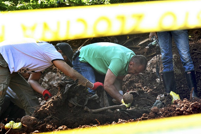 bosnian forensic expert murat hurtic inspects a set of human remains at the site of a newly discovered mass grave in the village of tugovo near eastern bosnian town of vlasenica on wednesday photo afp