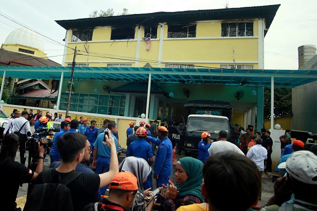 a malaysian national flag flutters outside burnt windows of the darul quran ittifaqiyah religious school in kuala lumpur on september 14 2017 twenty five people mostly teenage boys were killed on september 14 when a blaze tore through a malaysian religious school in what officials said was one of the country 039 s worst fire disasters for years photo afp