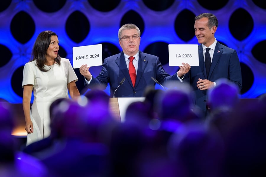 international olympic committee ioc president thomas bach c holds the cards bearing the name of paris 2024 and los angeles 2028 next to both cities 039 mayors anne hidalgo l and eric garcetti during the 131st ioc session in lima on september 13 2017 photo afp