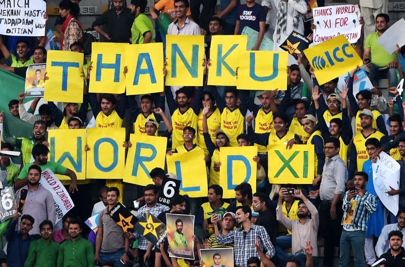 pakistani spectators hold placards at the gaddafi cricket stadium in lahore on september 15 2017 before the start of the third and final twenty 20 international match between the world xi and pakistan photo afp