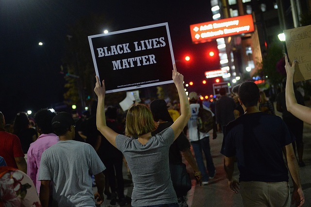 a woman walks with a sign during a protest action following a not guilty verdict on september 15 2017 in st louis missouri protests erupted today following the acquittal of former st louis police officer jason stockley who was charged with first degree murder last year in the shooting death of motorist anthony lamar smith in 2011 photo afp