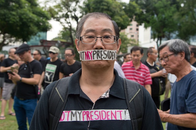 a man takes part in a protest against the walkover victory of halimah yacob as singapore 039 s president at hong lim park in singapore on september 16 2017 hundreds of singaporeans angered by the walkover victory of its first female president gathered in a downtown park on september 16 for a quot silent sit in quot in a rare political protest denouncing the lack of an election photo afp