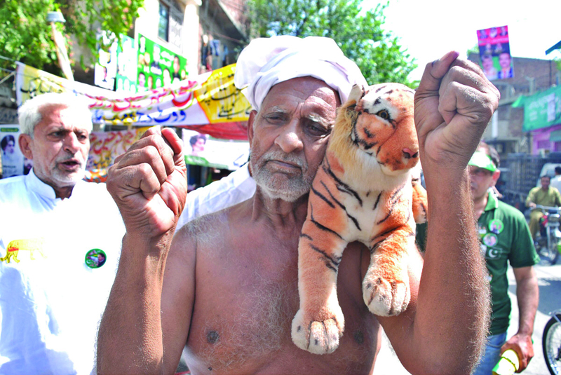 a topless elderly man carries a stuffed tiger toy to express his support for his political outfit photo nni