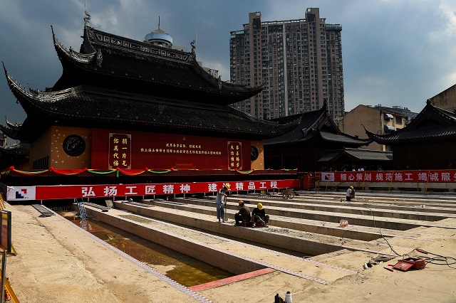 this file picture taken on september 5 2017 shows construction personnel working to relocate the main hall of the 135 year old yufo temple also known as the jade buddha temple in shanghai the main hall and statues of the temple in central shanghai have been moved 30 metres 100 feet on rails to ease crowding at the popular site photo afp