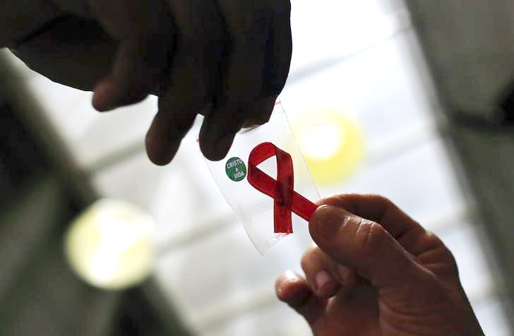 a nurse l hands out a red ribbon to a woman photo reuters