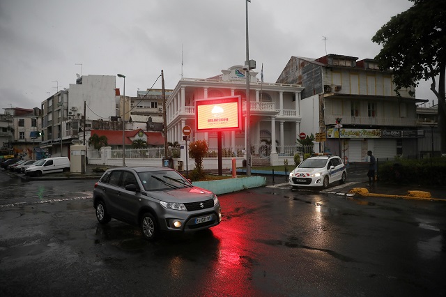 a car passes next to a banner warning of a quot red alert quot for rains as hurricane maria approaches in pointe a pitre guadeloupe island france september 18 2017 photo reuters