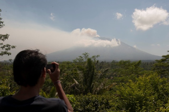 a local resident takes a picture of mount agung an active volcano that authorities say is showing increased activity from a monitoring station in rendang village karangasem on the resort island of bali indonesia september 19 2017 photo reuters