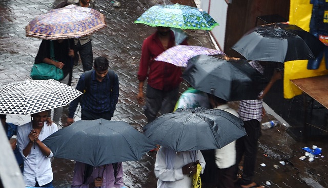 indian commuters walk amidst rain in mumbai on september 20 2017 dozens of flights were diverted from mumbai after a spicejet plane overshot the runway and became stuck in the mud as heavy rain lashed india 039 s financial capital and caused travel chaos september 20 schools and colleges also closed for the day as a precaution after severe monsoon rain late september 19 and overnight led to fears of widespread flooding photo afp