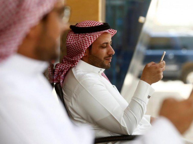 saudi men explore social media on their mobile devices as they sit at a cafe in riyadh photo reuters