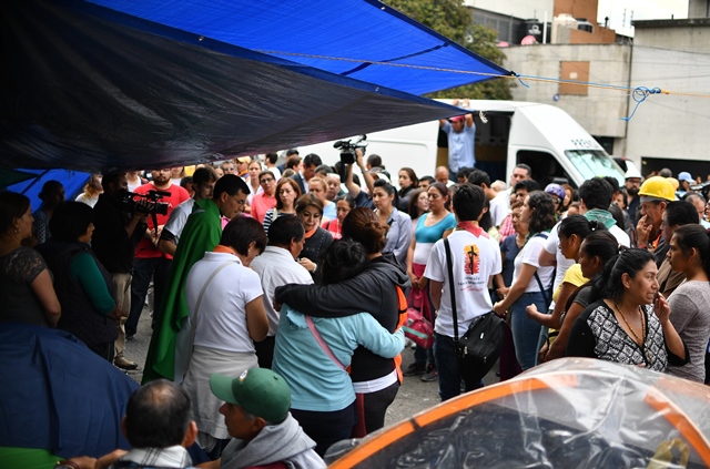relatives of people trapped in a building that collapsed after the earthquake participate in a mass at a temporary shelter in front of the damaged building in mexico city on september 22 2017 photo afp