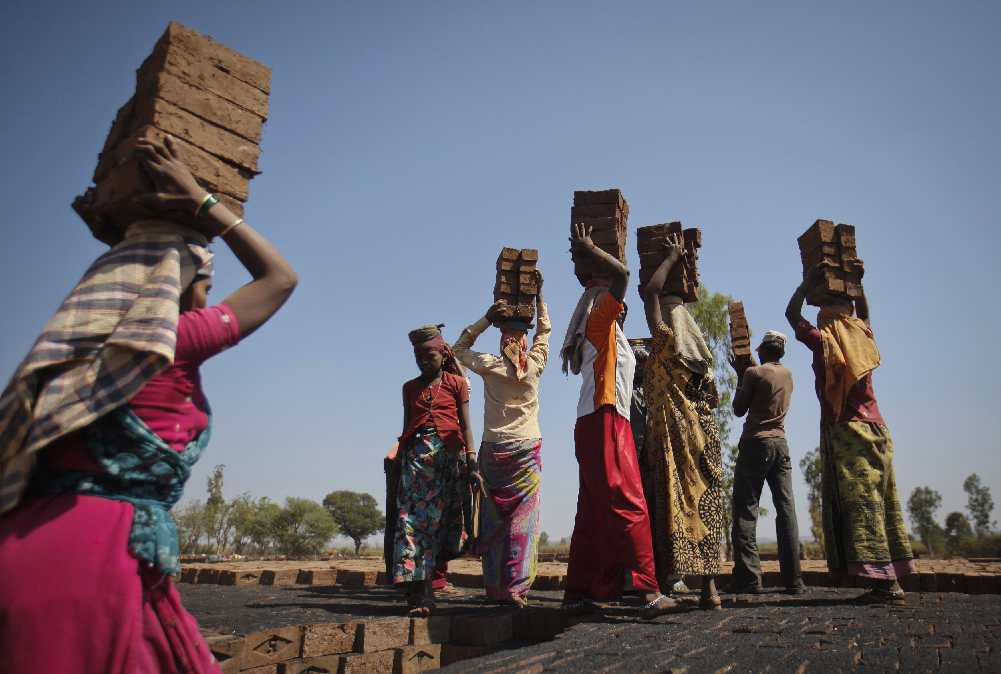 labourers carry bricks to be baked in a kiln at a brickyard photo reuters