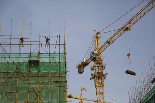 labourers work on the scaffolding of a construction site at an industrial zone in beijing photo reuters labourers work on the scaffolding of a construction site at an industrial zone in beijing photo reuters