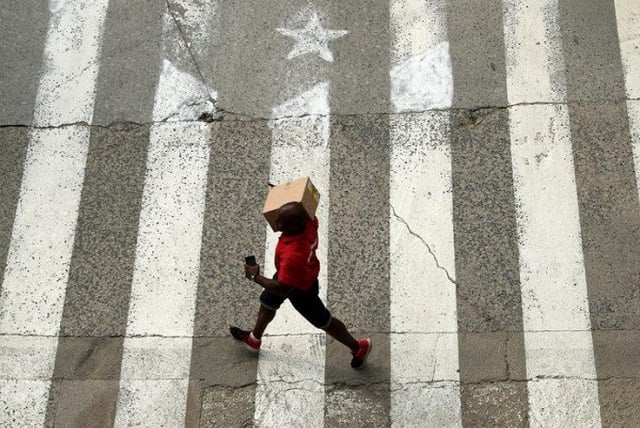 a man walks past a crosswalk painted in the form of an estelada catalan pro independence flag in arenys de munt north of barcelona spain photo reuters