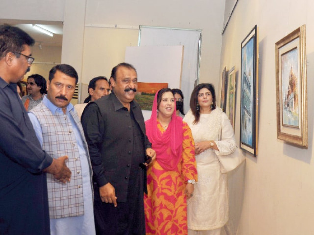 visitors explore the paintings at an exhibition held at the punjab arts council on wednesday photo express visitors explore the paintings at an exhibition held at the punjab arts council on wednesday photo express