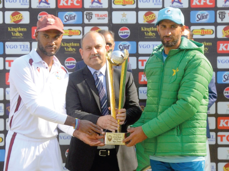 wi skipper kraigg brathwaite and pak captain shan masood jointly hold the series trophy at multan on monday photo afp