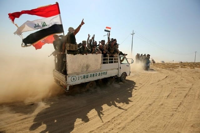 iraqi paramilitaries of the popular mobilisation force flash the victory sign as they advance on the islamic state group held enclave around the northern town of hawija on september 22 2017 photo afp