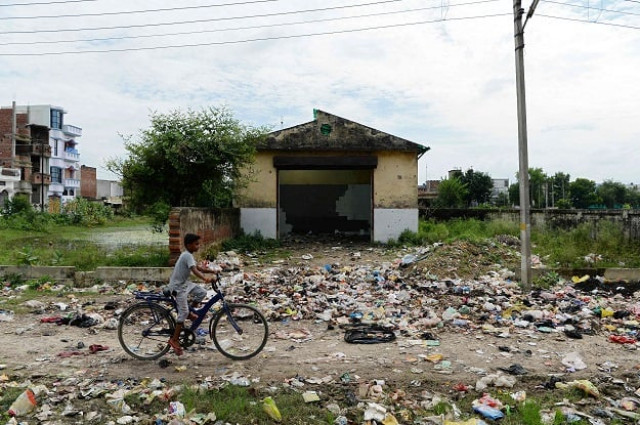 a boy rides a bicycle near a littered path in gonda district in the indian state of uttar pradesh photo afp a boy rides a bicycle near a littered path in gonda district in the indian state of uttar pradesh photo afp