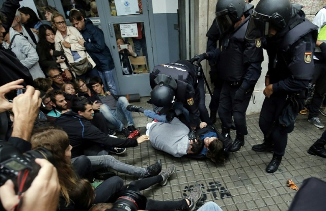 spanish police immobilize two people outside a polling station in barcelona as catalonia holds an independence referendum banned by madrid photo afp