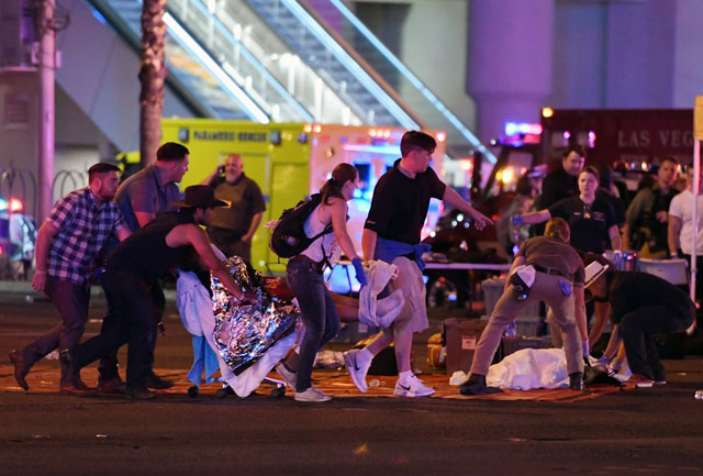 an injured person is tended to in the intersection of tropicana ave and las vegas boulevard after a mass shooting at a country music festival nearby on october 2 2017 in las vegas nevada photo afp