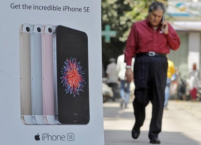 a man speaks on his mobile phone as he walks past an apple iphone se advertisement billboard in a street in new delhi india april 25 2016 photo reuters a man speaks on his mobile phone as he walks past an apple iphone se advertisement billboard in a street in new delhi india april 25 2016 photo reuters