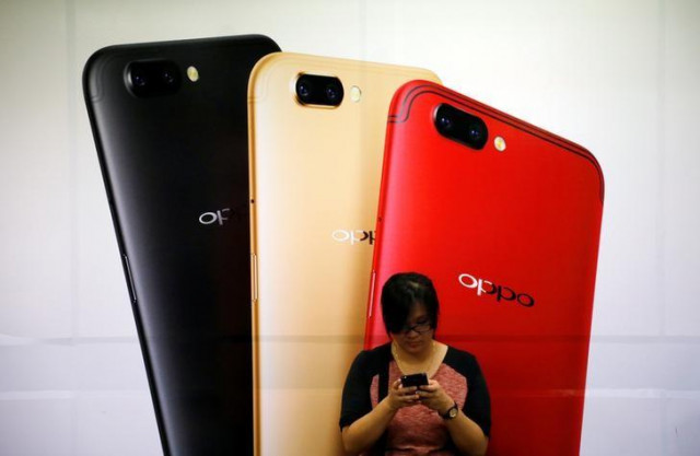a woman uses her mobile phone next to an oppo mobile handset advertisement in singapore august 7 2017 photo reuters a woman uses her mobile phone next to an oppo mobile handset advertisement in singapore august 7 2017 photo reuters